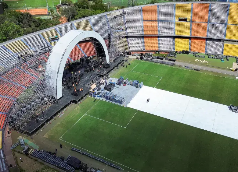 Multitud en un estadio colombiano durante un concierto nocturno con luces de escenario, reflejando el impacto económico de US$100 millones en 2025