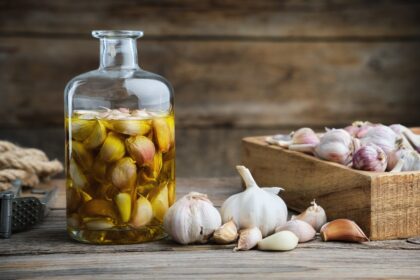 Dientes de ajo enteros infusionandose en aceite de oliva virgen extra para extraer alicina sin fructanos irritantes