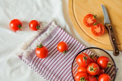 Cuchillo de sierra cortando un tomate siguiendo los tabiques internos para evitar que pierda jugo en la ensalada