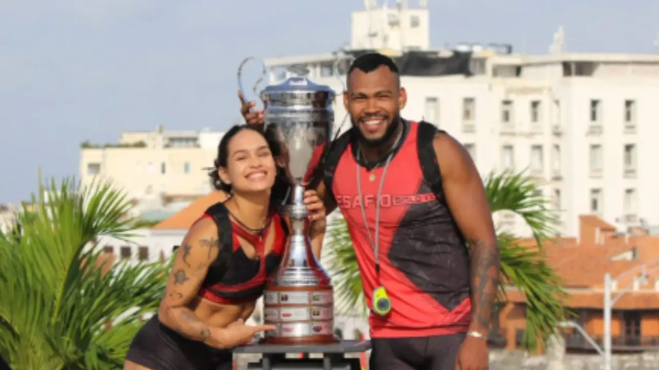 Zambrano y Miryan celebrando su victoria en la final del Desafío Siglo XXI 2026, con la copa en Cartagena al atardecer