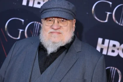 Actor caracterizado como Aerys II Targaryen, el Rey Loco, en una escena teatral oscura con espadas y sombras, revelando su paranoia en Poniente