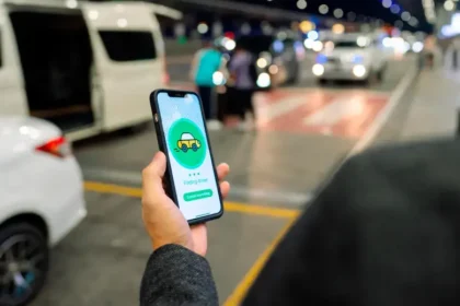 Conductor de Uber revisando su teléfono con expresión de alivio tras el retiro del proyecto de ley que imponía multas de $39 millones por servicio
