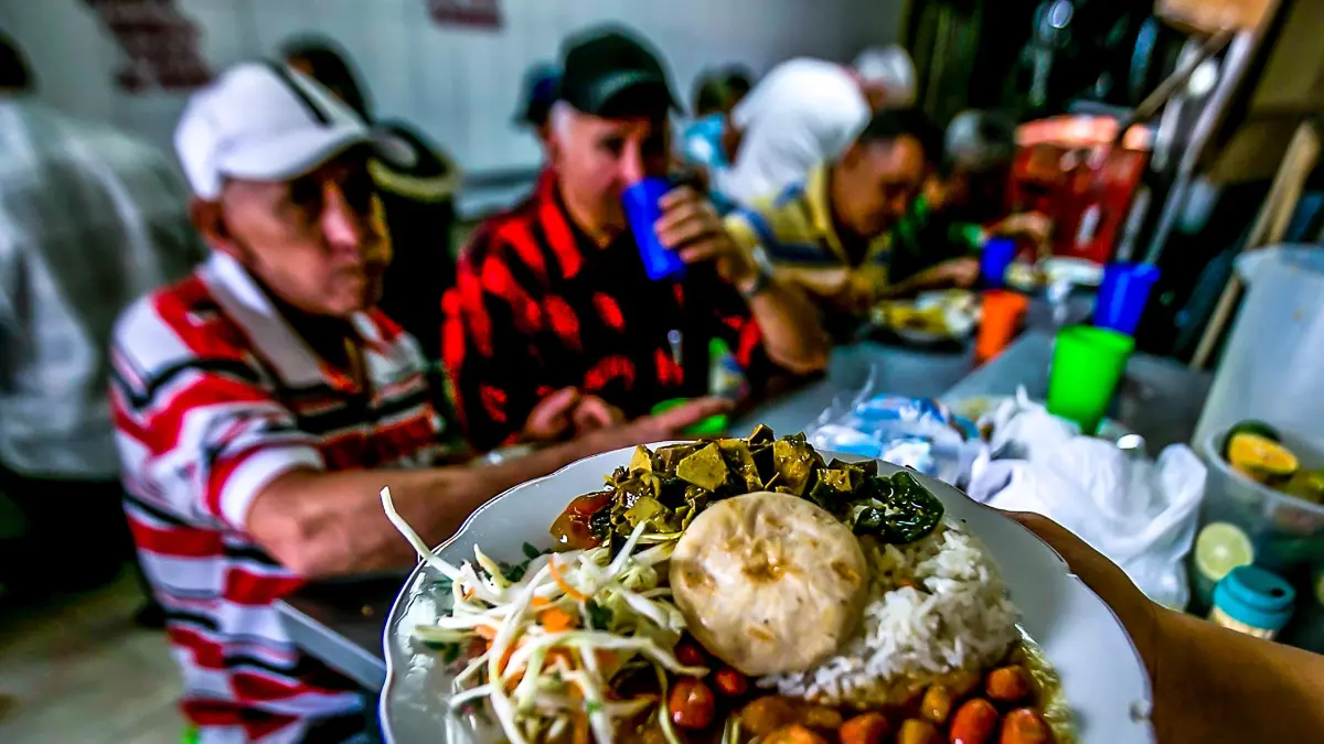 Gráfico comparativo de alzas en precios de comidas en restaurantes y transporte urbano en Colombia durante enero 2026, con datos del Dane