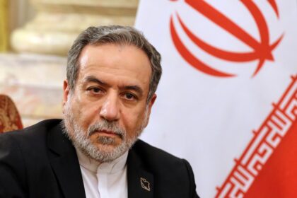 Delegados iraníes y estadounidenses en la embajada de Omán en Ginebra durante las negociaciones nucleares con despliegues militares de fondo