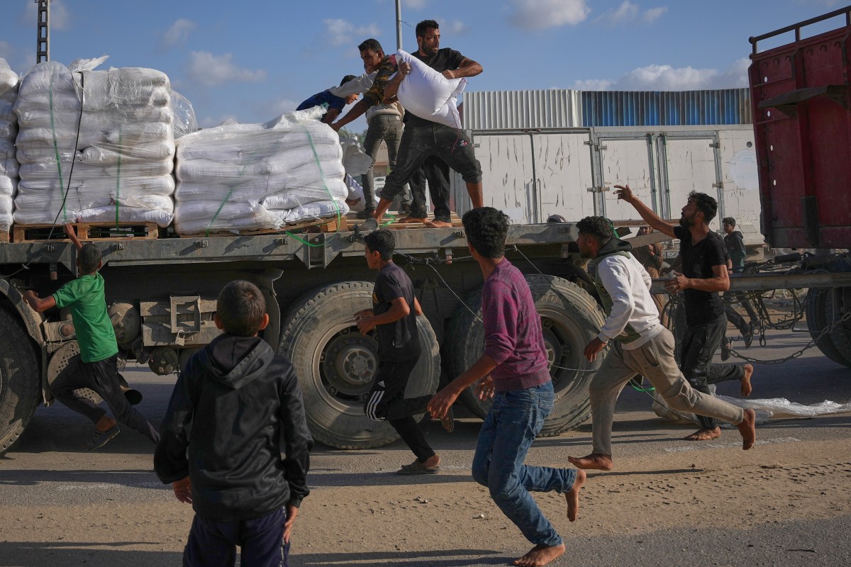 Trabajadores humanitarios de ONG vetadas en Gaza cargando cajas con suministros médicos y alimentos para la población afectada