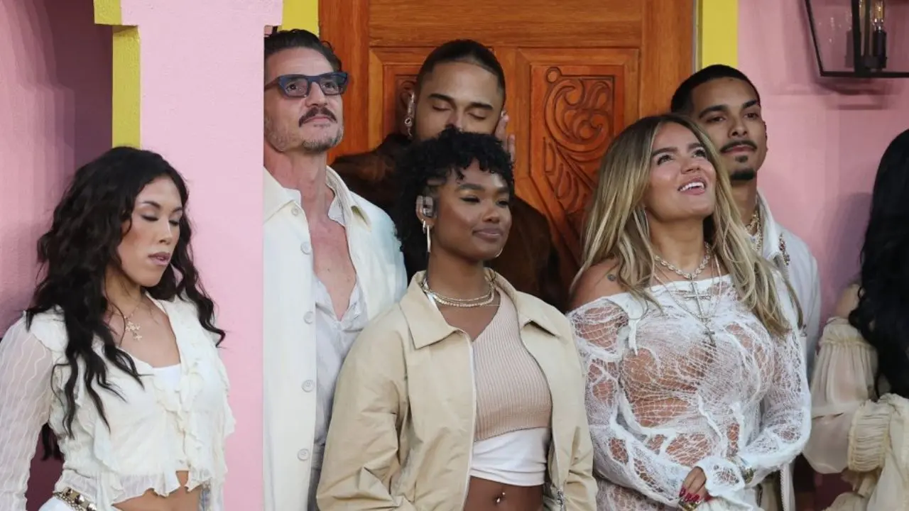 Bad Bunny y Karol G frente a la réplica de una casita puertorriqueña en el escenario del Super Bowl 2026, rodeados de banderas latinas y luces vibrantes