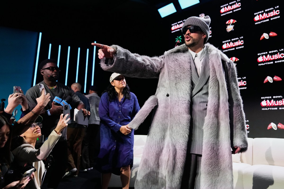 Bad Bunny en el escenario del Super Bowl con luces y público, acompañado de mensajes de apoyo de Katy Perry y Madonna en pantalla gigante