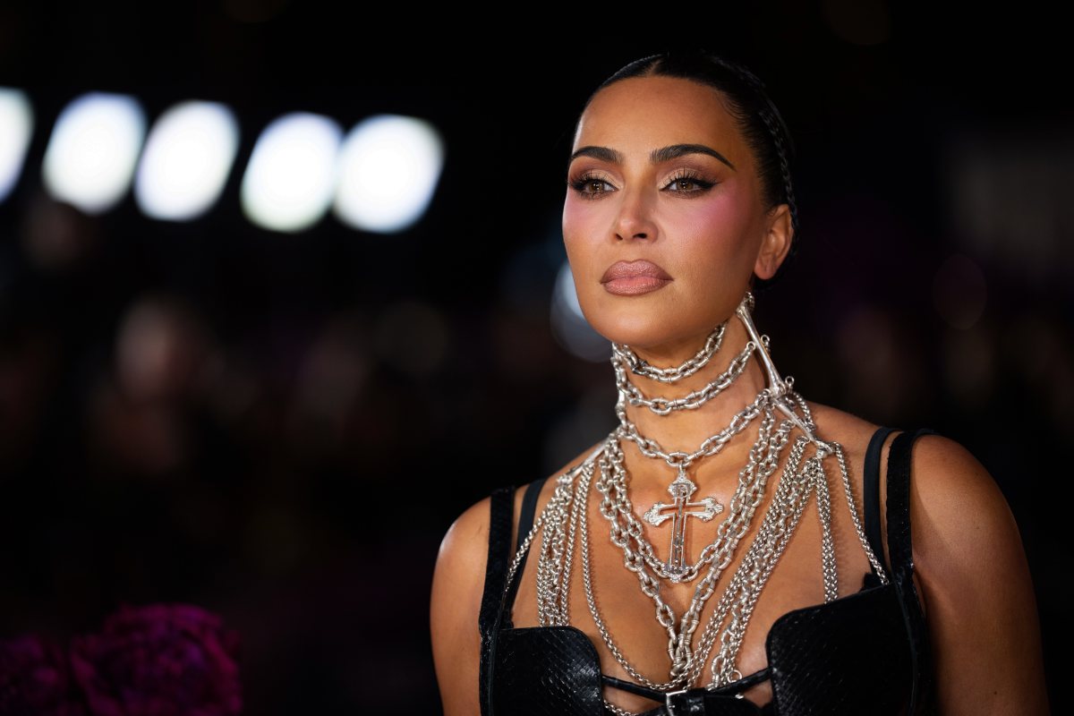Kim Kardashian y Lewis Hamilton sentados en asientos VIP durante el Super Bowl LX, con expresiones cercanas y sonrisas
