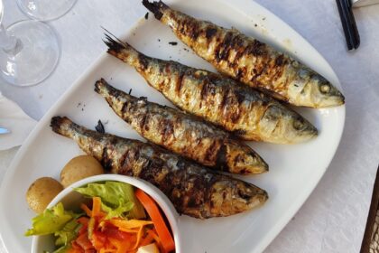 Sardinas frescas en plato con limón y hierbas, ricas en omega-3 y proteínas para salud cardiovascular y cerebral según estudios científicos