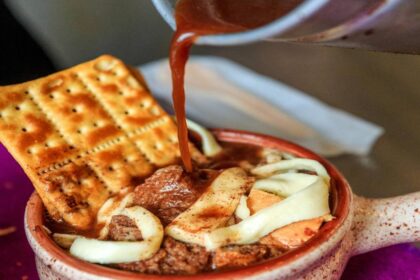 Plato de migao tradicional antioqueño servido en local de franquicia, con ingredientes frescos y ambiente acogedor como la casa de la abuela