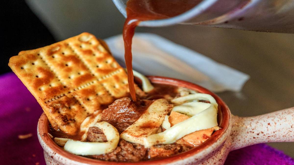 Plato de migao tradicional antioqueño servido en local de franquicia, con ingredientes frescos y ambiente acogedor como la casa de la abuela