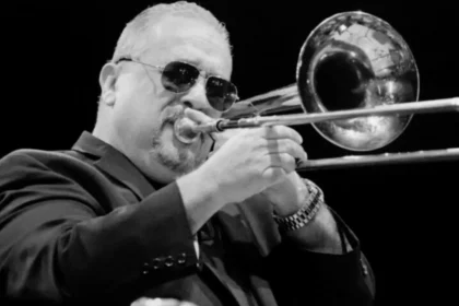 Willie Colón tocando el trombón en un escenario, símbolo de la revolución musical que definió la salsa moderna