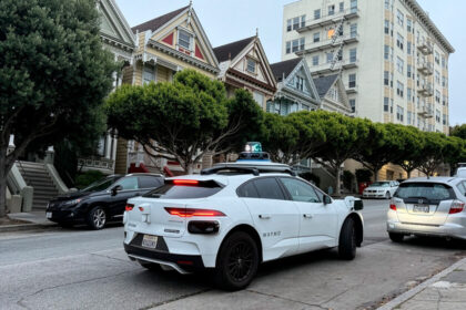 Robotaxi eléctrico Jaguar I-PACE con puerta entreabierta en una calle de San Francisco, mostrando el fallo que frena su autonomía total