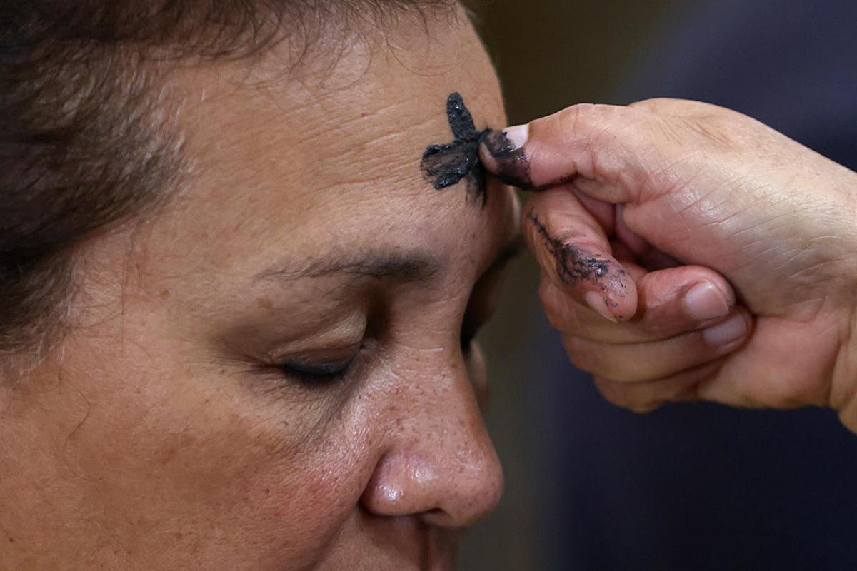 Sacerdote trazando una cruz de ceniza en la frente de un fiel durante el Miércoles de Ceniza, símbolo de arrepentimiento y preparación espiritual para la Cuaresma