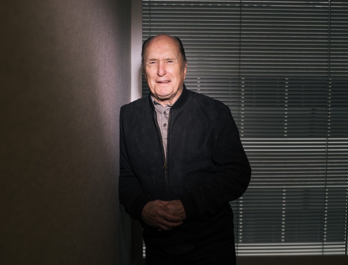 Robert Duvall en su papel de Tom Hagen en 'El Padrino', con traje oscuro y mirada penetrante, símbolo de su legado actoral