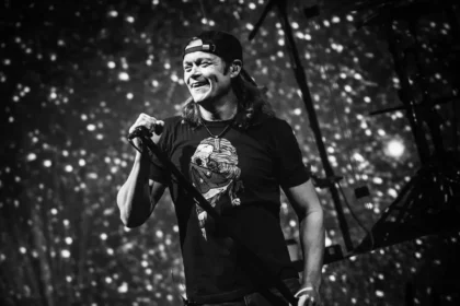 Brad Arnold cantando 'Kryptonite' en un concierto masivo de 3 Doors Down ante 50.000 fans, con su característico micrófono en mano y luces de escenario al fondo