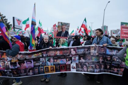 Estudiantes iraníes con banderas y pancartas durante protestas en universidades de Teherán, enfrentando posturas opuestas