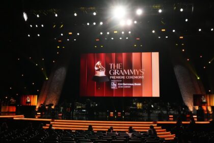 Kendrick Lamar con 26 premios Grammy en la ceremonia 2026, celebrando su récord con trofeo en mano junto a Bad Bunny y Lady Gaga