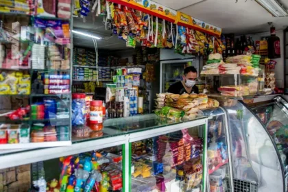 Dueño de tienda de barrio revisando insumos recibidos por el subsidio de $4,9 millones para fortalecer su negocio local