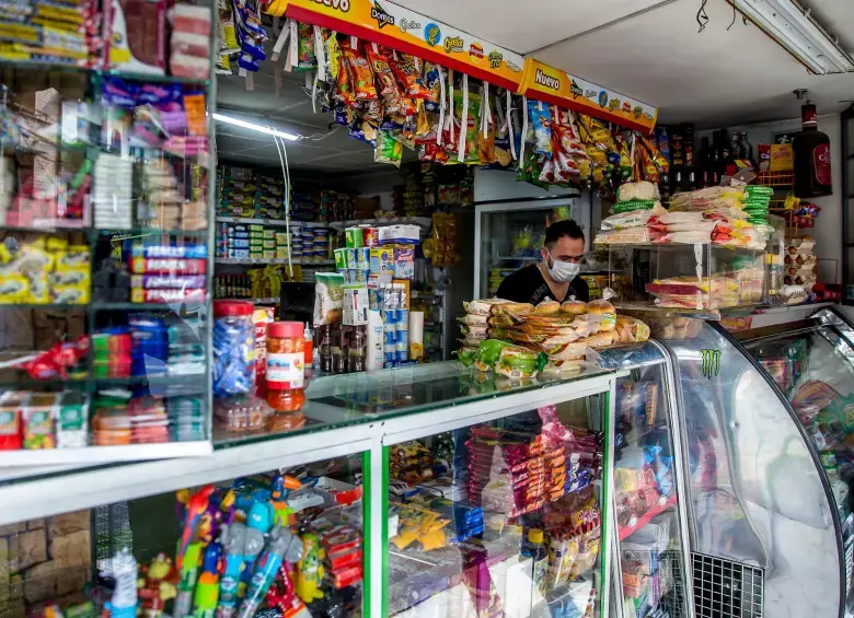 Dueño de tienda de barrio revisando insumos recibidos por el subsidio de $4,9 millones para fortalecer su negocio local
