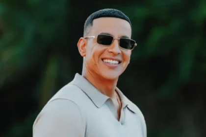 Daddy Yankee en un escenario con luces doradas, representando el homenaje de Puerto Rico con una carretera en su honor