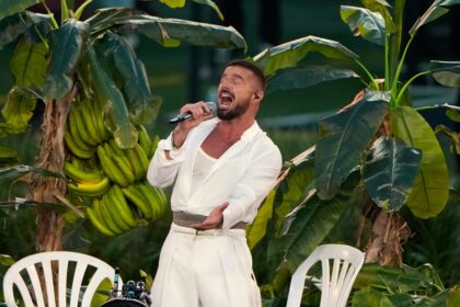 Ricky Martin y Bad Bunny en un abrazo emotivo tras su actuación en el Super Bowl, con bailarines y equipo de producción al fondo