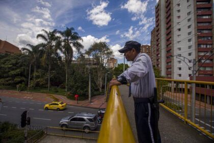 Trabajador de aseo con uniforme y herramientas en un centro comercial vacío tras recortes por alza del salario mínimo en Colombia