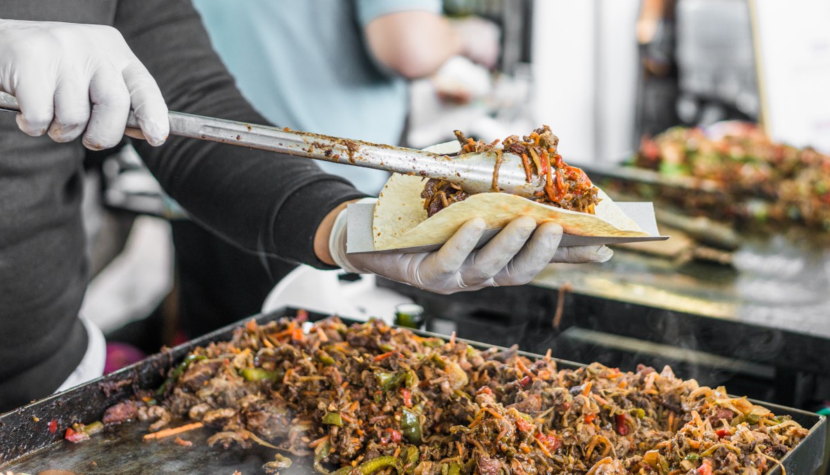 Camión de tacos mexicanos en Tokio con comal bola tradicional, sirviendo suadero y carnitas auténticas bajo el cielo urbano