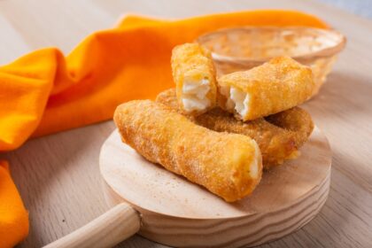 Tequeños de plátano dorados y crujientes rellenos de queso blanco, servidos en plato rústico con semillas de chía espolvoreadas