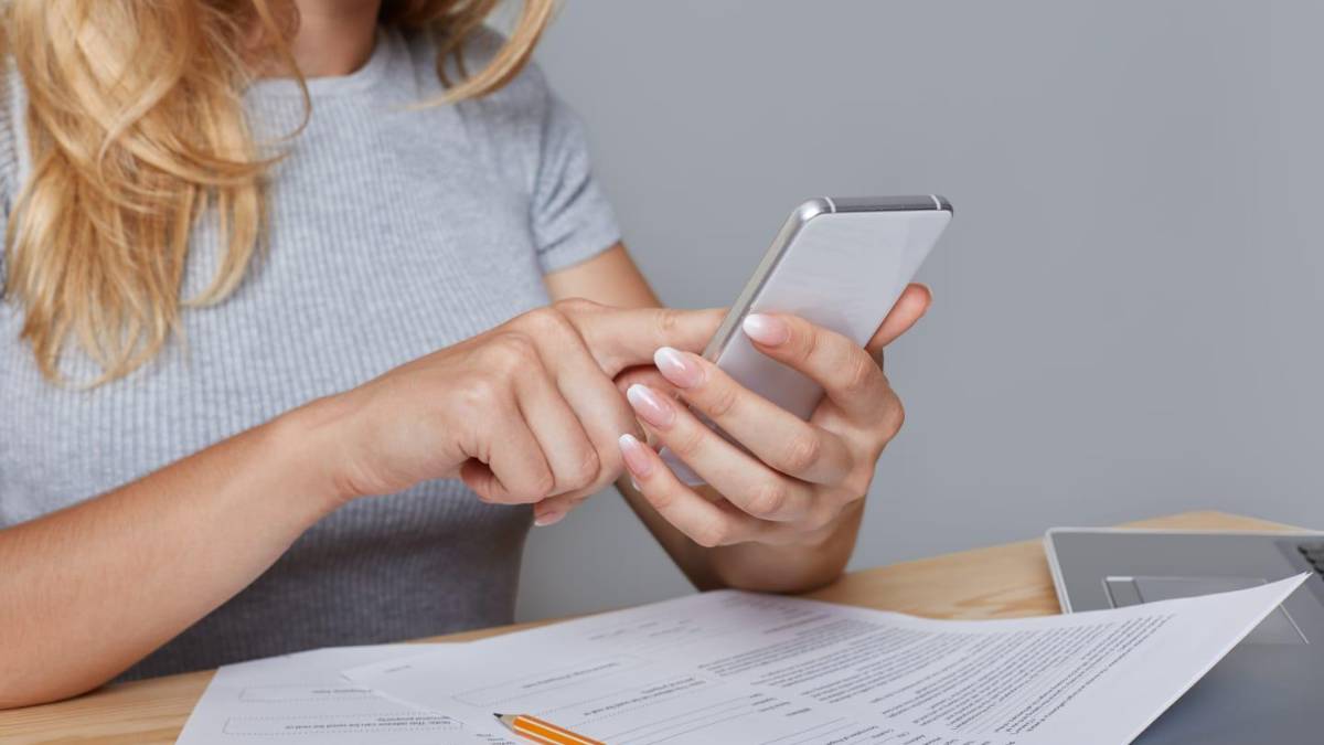 Persona revisando en su celular un mensaje de 'Firme aquí' con requisitos legales para firma digital por WhatsApp en Colombia