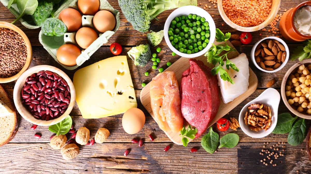 Plato con carne, quesos y vegetales mostrando bacterias resistentes a antibióticos bajo microscopio