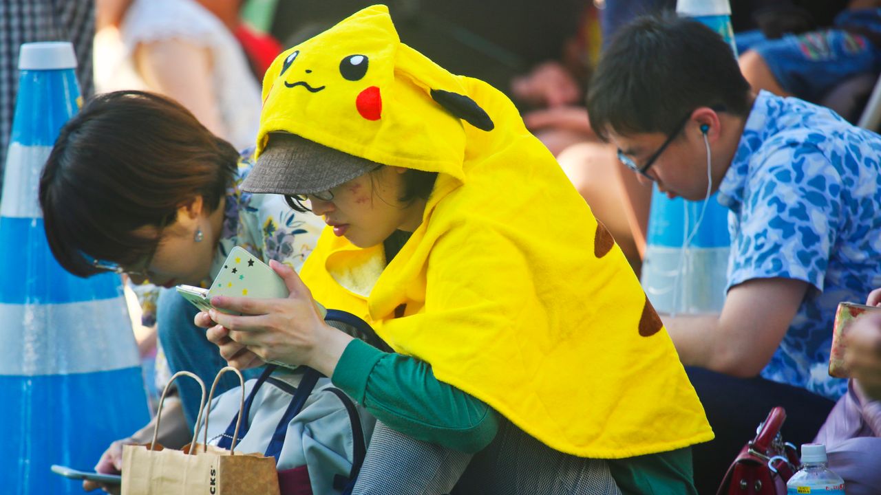 Jugador de Pokémon Go capturando un Pokémon en un parque urbano, sin saber que sus datos geoespaciales entrenan IA para mapas 3D y robots autónomos