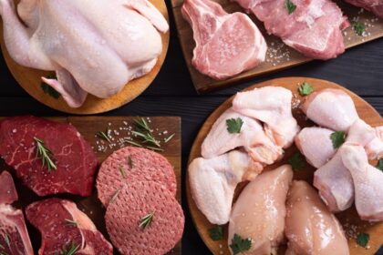 Mano presionando filete de carne roja con texto 'prueba de frescura' y fondo de carnicería con luces brillantes