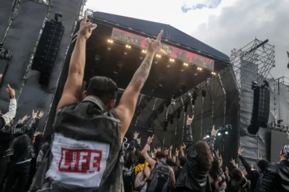 Multitud vibrando en Rock al Parque 2026 bajo luces de escenario con banda icónica en el Simón Bolívar, 30 años de rock gratuito