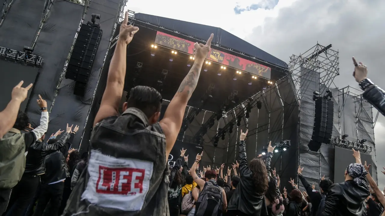 Multitud vibrando en Rock al Parque 2026 bajo luces de escenario con banda icónica en el Simón Bolívar, 30 años de rock gratuito