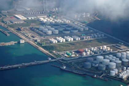 Puerto de Zhuhai en China con barcos cargando petróleo mientras conductores cruzan el puente de 55 km para buscar gasolina más barata