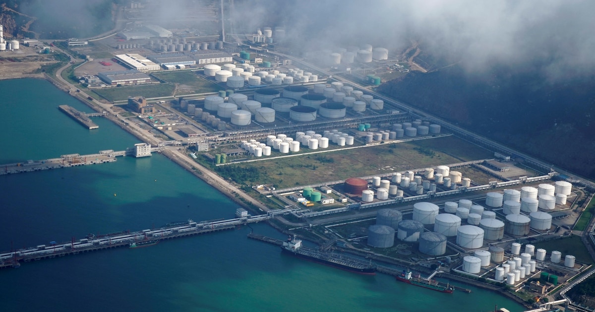 Puerto de Zhuhai en China con barcos cargando petróleo mientras conductores cruzan el puente de 55 km para buscar gasolina más barata