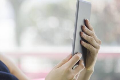 Gráfico de crecimiento de libros digitales en Colombia con un lector usando tablet y auriculares para audiolibros