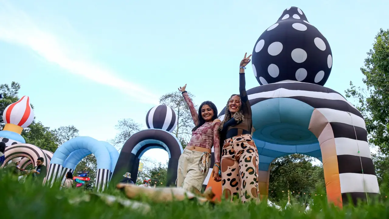 Asistentes al Estéreo Picnic 2026 mostrando termos vacíos y bloqueador solar en la entrada del festival bajo el sol
