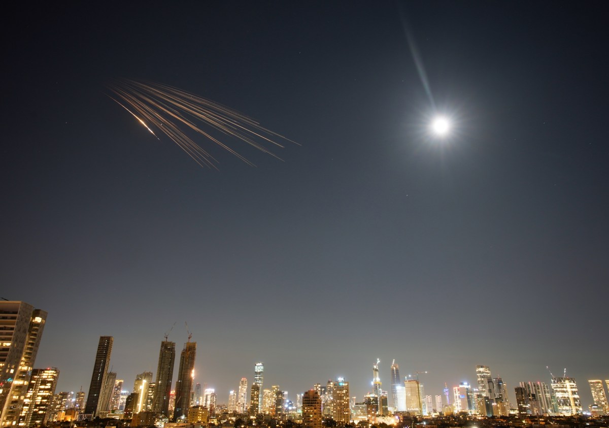 Misiles iraníes en vuelo durante el ataque coordinado a Israel y bases estadounidenses en Irak con humo al fondo