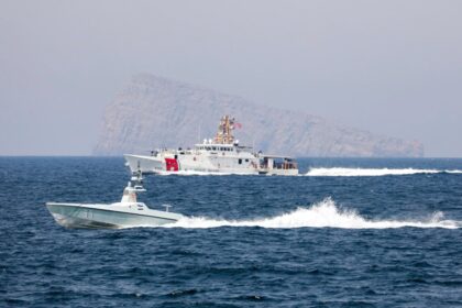 Bandera de Japón sobre un mapa del Estrecho de Ormuz con un barco petrolero en primer plano, simbolizando la tensión geopolítica y la dependencia energética