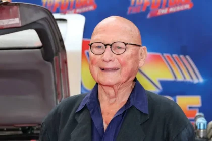 James Tolkan caracterizado como el Sr. Strickland en 'Volver al Futuro', con mirada severa y traje formal en el Instituto Hill Valley
