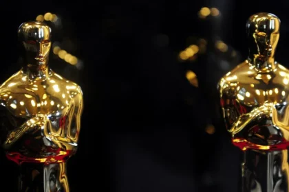 Cartel oficial de los Óscar 2026 con las películas 'Pecadores' y 'El Agente Secreto' destacadas sobre fondo dorado del Dolby Theatre