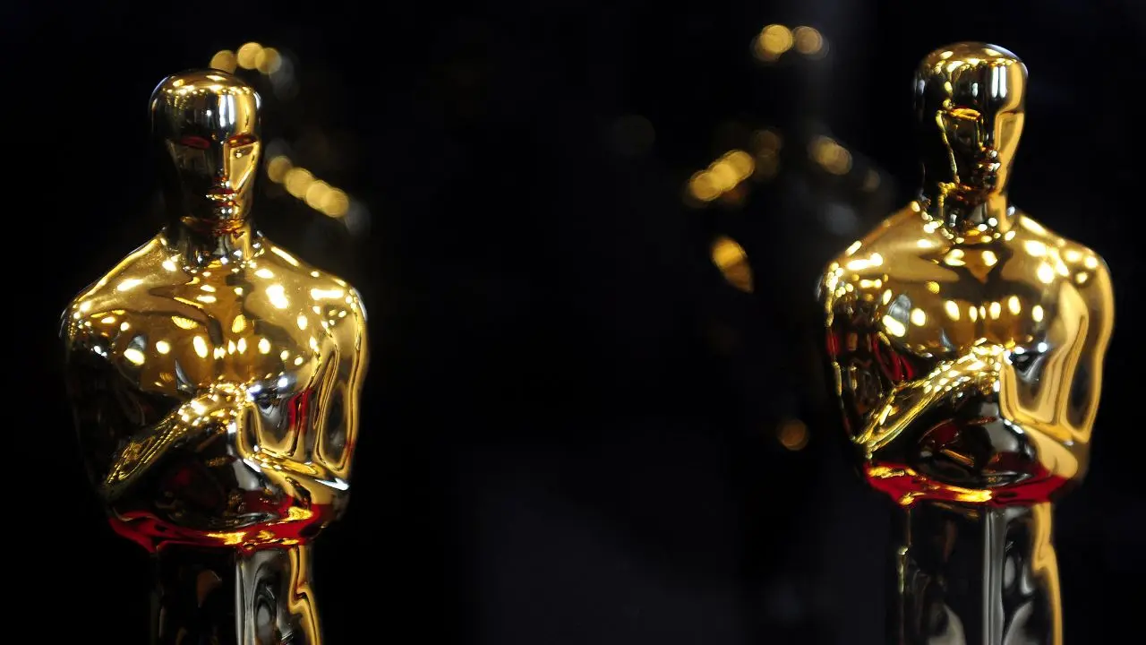 Cartel oficial de los Óscar 2026 con las películas 'Pecadores' y 'El Agente Secreto' destacadas sobre fondo dorado del Dolby Theatre