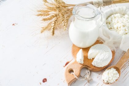 Cuajos blancos de requesón casero colándose en gasa sobre un bol, con suero líquido separándose naturalmente