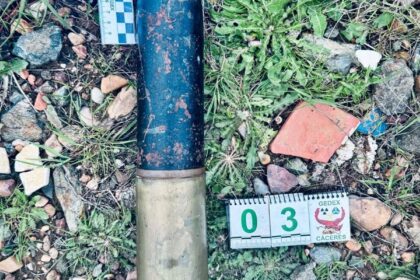 Proyectil de artillería de 65 mm de la Guerra Civil encontrado intacto en un sendero rural de Badajoz, con vaina original visible sobre tierra seca