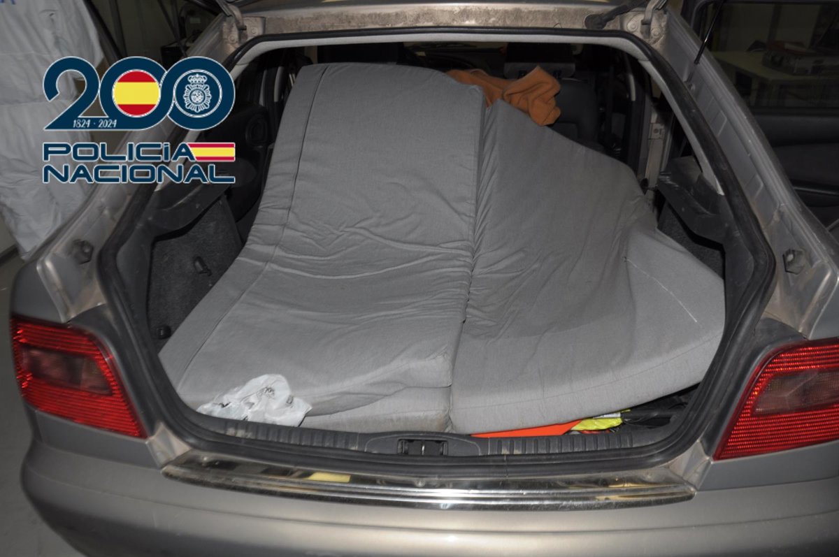 Agente policial deteniendo a un hombre junto a un coche en Málaga, vinculado a agresiones sexuales a jóvenes vulnerables