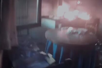 Agentes de la Guardia Civil usando extintor para apagar un incendio en la cocina de una casa rural con humo visible