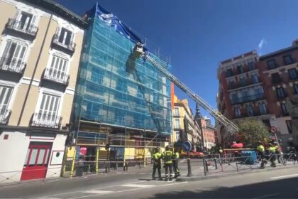 Bomberos de Madrid retirando un andamio inestable en la calle Toledo tras el temporal de viento, con grúas y equipos de seguridad