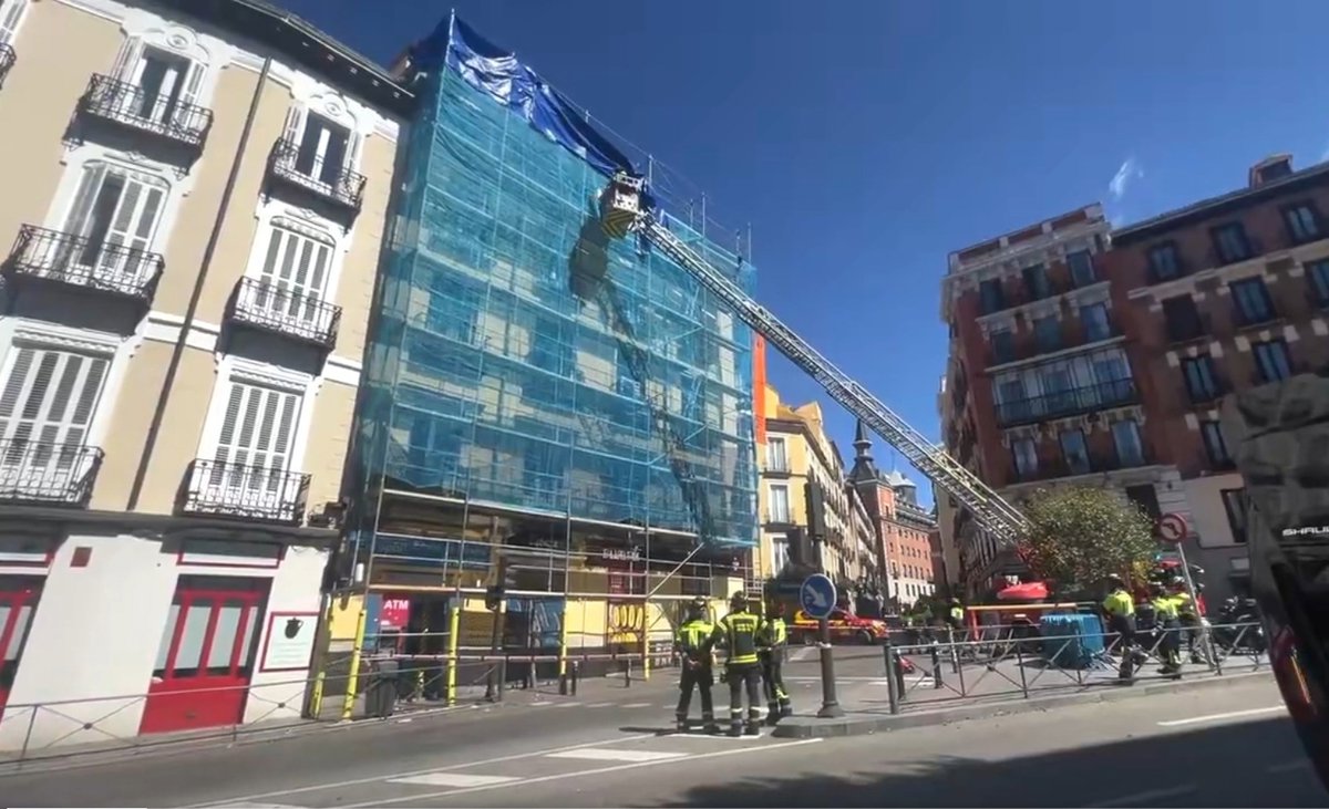 Bomberos de Madrid retirando un andamio inestable en la calle Toledo tras el temporal de viento, con grúas y equipos de seguridad